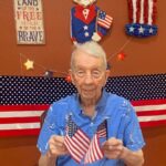 Old man holding the Flags of America
